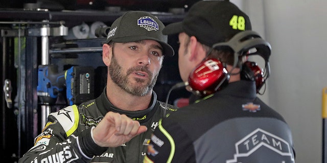 Jimmie Johnson talks with crew chief Chad Knaus during practice for the Daytona 500.
