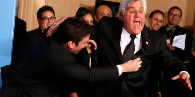 Late night talk show hosts Jimmy Fallon (L) and Jay Leno joke around backstage at the 70th annual Golden Globe Awards in Beverly Hills, California, January 13, 2013.