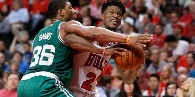 Chicago Bulls' Jimmy Butler (21) is pressured by Boston Celtics' Marcus Smart during the second half in Game 4 of an NBA basketball first-round playoff series in Chicago, Sunday, April 23, 2017. The Celtics won 104-95. (AP Photo/Charles Rex Arbogast)