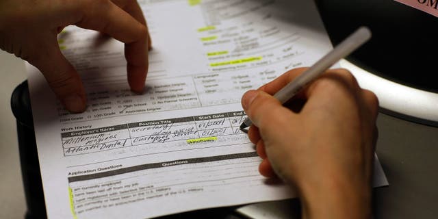 Marie Annoval, who was laid off from her job last month, enters her work history on an application for unemployment benefits. (Photo by Joe Raedle/Getty Images)