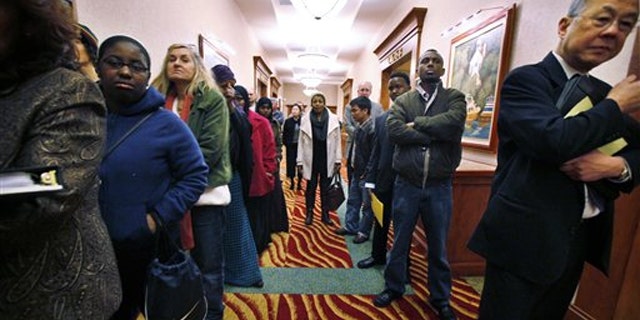 In this March 1 photo, job seekers line the hall at a job fair in SeaTac, Wash.