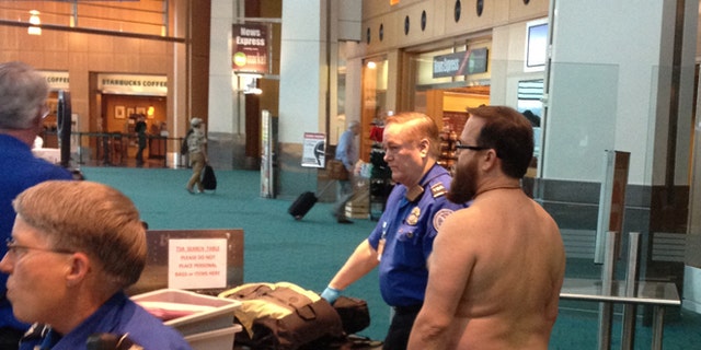 April 17, 2012: In this file photo taken at Portland International Airport, shows John E. Brennan standing naked after he stripped down while going through a security screening area, as a protest against airport security procedures.