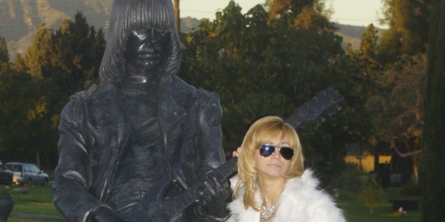 Linda Ramone, widow of Johnny Ramone poses next to a statue of his likeness in Los Angeles.