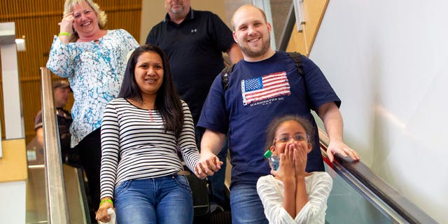 Josh Holt returned with wife, Thamara Caleno, left, and daughter, Marian, bottom, to a crowd of friends and family in Salt Lake City.