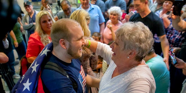 Holt's grandmother, Linda Holt, draped an American flag on Josh Holt's shoulder upon his return to Salt Lake City.