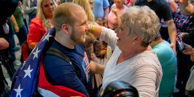 Holt's grandmother, Linda Holt, draped an American flag on Josh Holt's shoulder upon his return to Salt Lake City.
