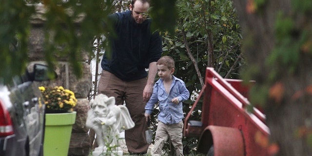 ADDS NAME OF SON JONAH-Joshua Boyle and his son Jonah play in the garden at his parents house in Smiths Falls, Ont., on Saturday, Oct. 14, 2017. A couple held hostage for five years by a Taliban-linked network and forced to raise three children while in captivity were initially targeted for ransom because of the impending birth of their first child, the Canadian man at the heart of the case speculated Saturday. Boyle said he and his wife Caitlan Coleman heard at least half a dozen reasons why they had been snatched from a village in Afghanistan and held against their will by the Haqqani network over the years they were imprisoned. (Lars Hagberg/The Canadian Press via AP)