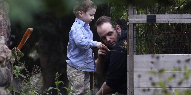 Joshua Boyle and son Jonah play in the garden at his parents house in Smiths Falls, Ont., on Saturday, Oct. 14, 2017. A couple held hostage for five years by a Taliban-linked network and forced to raise three children while in captivity were initially targeted for ransom because of the impending birth of their first child, the Canadian man at the heart of the case speculated Saturday. Boyle said he and his wife Caitlan Coleman heard at least half a dozen reasons why they had been snatched from a village in Afghanistan and held against their will by the Haqqani network over the years they were imprisoned. (Lars Hagberg/The Canadian Press via AP)