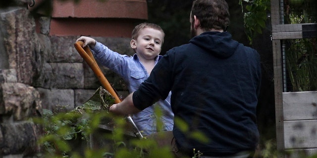 ADDS NAME OF SON JONAH-Joshua Boyle and his son Jonah play in the garden at his parents house in Smiths Falls, Ont., on Saturday, Oct. 14, 2017. A couple held hostage for five years by a Taliban-linked network and forced to raise three children while in captivity were initially targeted for ransom because of the impending birth of their first child, the Canadian man at the heart of the case speculated Saturday. Boyle said he and his wife Caitlan Coleman heard at least half a dozen reasons why they had been snatched from a village in Afghanistan and held against their will by the Haqqani network over the years they were imprisoned. (Lars Hagberg/The Canadian Press via AP)