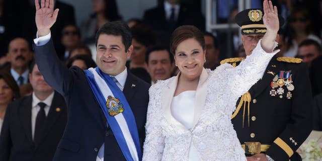 Honduras' President Juan Orlando Hernandez, left, and his wife Ana Rosalinda wave after his swearing in ceremony as new president in Tegucigalpa, Honduras, Monday, Jan. 27, 2014. (AP Photo/Arnulfo Franco)