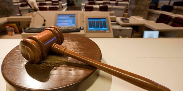 The gavel stands ready as Alabama House Public Information Officer Clay Redden, rear, makes preparations House chamber in Montgomery, Ala., on Friday, Dec. 3, 2010 a for the special session on ethics legislation called by Gov. Bob Riley. The lawmakers come into session next Wednesday. (AP Photo/Dave Martin)