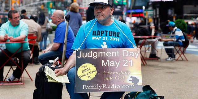mężczyzna siedzi na nowojorskim Times Square w 2011 roku ostrzegając o końcu świata, zgodnie z przewidywaniami Ewangelisty kaznodziei Harolda Campinga's Times Square in 2011 warning about the end of the world, as predicted by Evangelist preacher Harold Camping