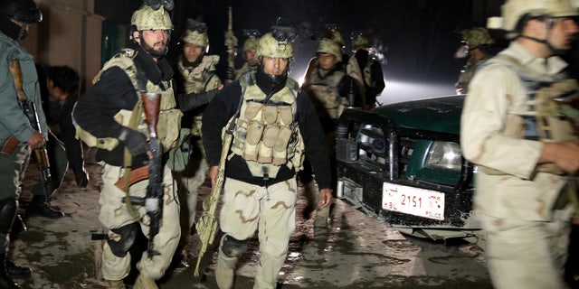 Jan. 17, 2014: Afghan security forces leave the site of a suicide attack in Kabul, Afghanistan.