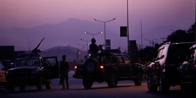 An Afghan army officer mans a heavy gun mounted to a vehicle at the entrance to the InterContinental hotel, which came under attack in Kabul, Afghanistan, June 29.
