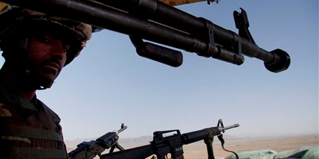 In this April 26 photo, a soldier of the Afghan National Army stands guard at a joint U.S. Marines observation post in Nawzad, Helmand province south of Kabul, Afghanistan.