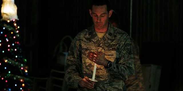 Dec. 24, 2010: A U.S. soldier carries a candle to light those of his colleagues during a ceremony on the eve of Christmas at the U.S. base of Camp Phoenix in Kabul, Afghanistan.