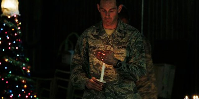 Dec. 24, 2010: A U.S. soldier carries a candle to light those of his colleagues during a ceremony on the eve of Christmas at the U.S. base of Camp Phoenix in Kabul, Afghanistan.