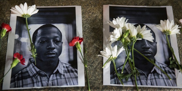 Flowers rest on top of pictures of Kalief Browder in New York. Browder had been held there for three years without being convicted of a crime. (Reuters)