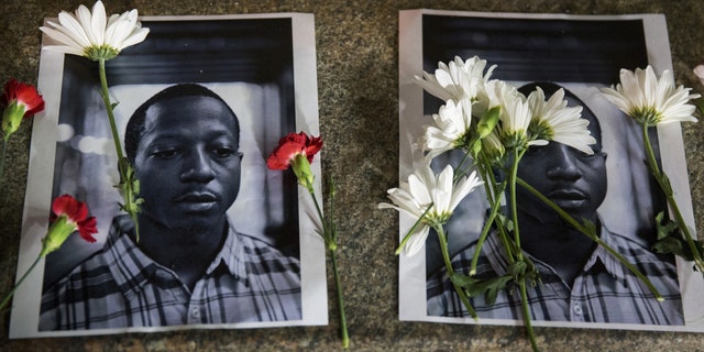 Flowers rest on top of pictures of Kalief Browder in New York. Browder had been held there for three years without being convicted of a crime. (Reuters)