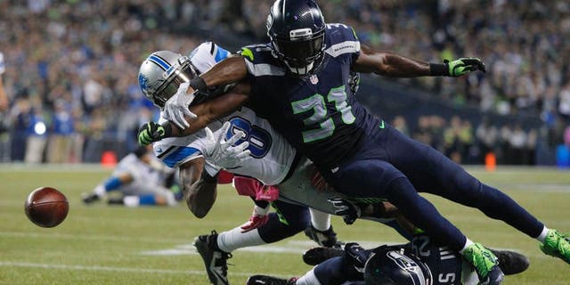 Oct 5, 2015; Seattle, WA, USA; Seattle Seahawks strong safety Kam Chancellor (31) forces a fumble by Detroit Lions wide receiver Calvin Johnson (81) during the fourth quarter at CenturyLink Field. Mandatory Credit: Joe Nicholson-USA TODAY Sports
