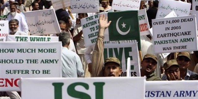Members of a Pakistani civil society hold placards during a rally in support of Pakistan's army and the Inter-Services Intelligence agency, ISI, in Karachi, Pakistan May 14.