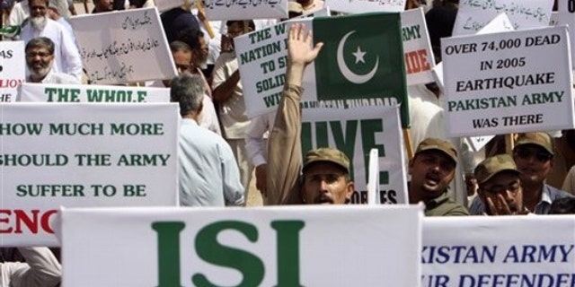 Members of a Pakistani civil society hold placards during a rally in support of Pakistan's army and the Inter-Services Intelligence agency, ISI, in Karachi, Pakistan May 14.