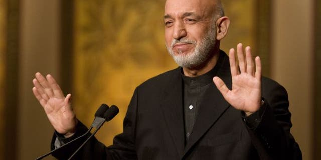 Jan. 11, 2013: Afghanistan President Hamid Karzai gestures for applause to stop before he began his speech at Georgetown University in Washington.
