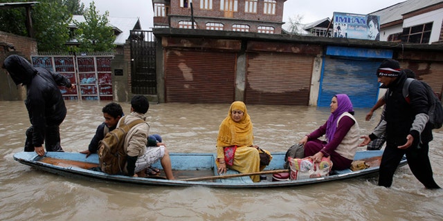 Sept. 4, 2014: Residents leave a flooded neighborhood on a boat in Srinagar, India. Authorities say heavy rains have triggered floods and landslides in the Indian portion of Kashmir, killing at least 14 people in the worst flooding in 22 years.