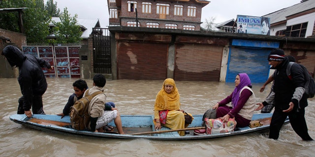 Sept. 4, 2014: Residents leave a flooded neighborhood on a boat in Srinagar, India. Authorities say heavy rains have triggered floods and landslides in the Indian portion of Kashmir, killing at least 14 people in the worst flooding in 22 years.