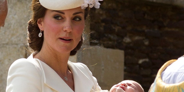 Kate Middleton carries Princess Charlotte after taking her out of a pram as they arrive for Charlotte