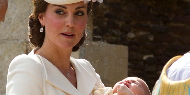 Kate Middleton carries Princess Charlotte after taking her out of a pram as they arrive for Charlotte