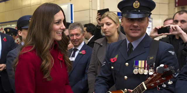 Nov. 7, 2013: Kate, the Duchess of Cambridge, left, reacts with an unidentified member of the Royal British Legion,  at Kensington High Street Station, in London.