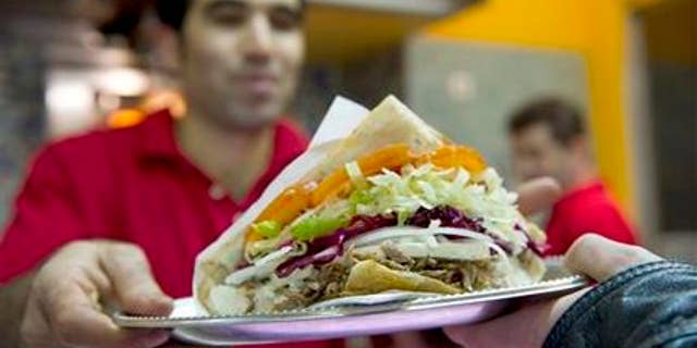 Turkish Abdullah Ekinci serves a doner kebab in a Turkish restaurant in Berlin, Germany, Sunday, March 21, 2010. Forget about bratwurst, currywurst and other kinds of sausages _ doner kebab, or shawarma, has overtaken traditional German fast food as the country's favorite snack on the go. (AP Photo/Gero Breloer)