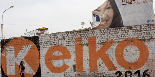 A woman walks past a mural promoting presidential candidate Keiko Fujimori in the Villa el Salvador district of Lima, Peru, Saturday, June 4, 2016. The South American country is gearing up for a tight June 5th runoff between Keiko Fujimori, the daughter of jailed former President Alberto Fujimori, and former World Bank economist Pedro Kuczynski. (AP Photo/Rodrigo Abd)