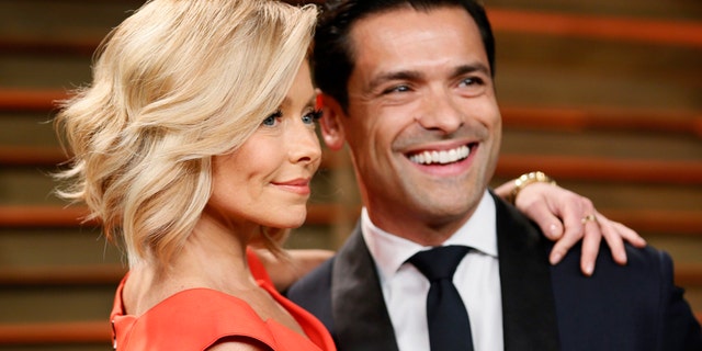 Television personality Kelly Ripa and her husband Mark Consuelos arrive at the 2014 Vanity Fair Oscars Party in West Hollywood, California March 2, 2014.