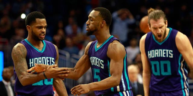 Jan 22, 2016; Orlando, FL, USA; Charlotte Hornets guard Kemba Walker (15) is congratulated by guard Troy Daniels (30) and forward Spencer Hawes (00) during the second half against the Orlando Magic at Amway Center. Charlotte Hornets defeated the Orlando Magic 120-116 in overtime. Mandatory Credit: Kim Klement-USA TODAY Sports