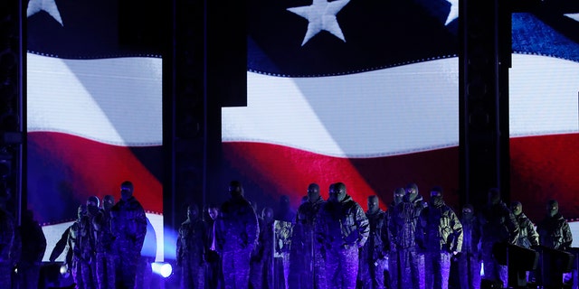 Kendrick Lamar (left, rear, in white shirt) performs a medley in front of an American flag at the 60th Annual Grammy Awards on Jan. 28, 2018.