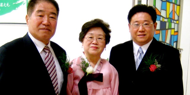 In this undated photo provided by the family of Kenneth Bae, Kenneth Bae, right, poses for a photo with his parents, Sung Seo Bae, left, and Myunghee Bae, center. Bae, a 45-year-old tour operator and Christian missionary was arrested last November while leading a group of tourists in the northeastern region of Rason in North Korea and has been detained for the past 11 months. Bae's family said on Thursday, Oct. 10, 2013, that Bae's mother, Myunghee Bae, is being allowed to visit him.