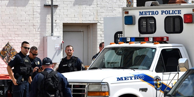 July 26, 2018: Officers with the Louisville Metro Police wait to load members of the Occupy ICE movement into a van at the rear of the Heyburn building.