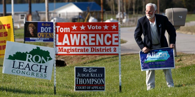 Nov. 3, 2014: Phinis Hundley, a labor organizer for Kentucky Democratic Senate candidate Alison Lundergan Grimes puts out a campaign sign in front of the United Auto Workers hall.