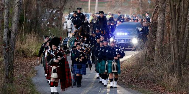 Nov. 11, 2015: Pipers and members of the Lexington Mounted Police lead the hearse during the funeral procession for Richmond Police Officer Daniel Ellis near Dunnville, Ky.