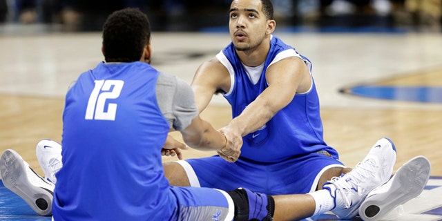 March 25, 2015: Kentucky's Trey Lyles, right, and Karl-Anthony Towns (12) stretch during practice at the NCAA college basketball tournament in Cleveland.