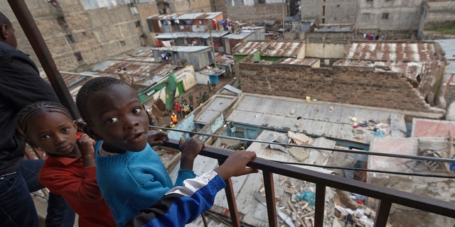 Child residents of a neighboring building look out over their balcony at the scene of a five-storey collapsed building in the Huruma neighborhood of Nairobi, Kenya, June 3, 2018.
