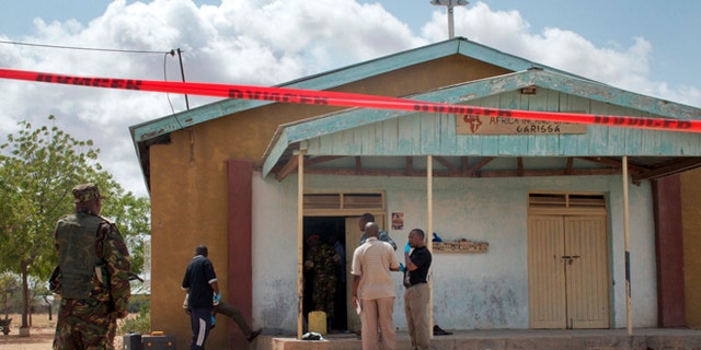 July 1, 2012: Members of the Kenyan security forces inspect the scene, as a body lies covered by a sheet, outside the African Inland Church in Garissa, Kenya.