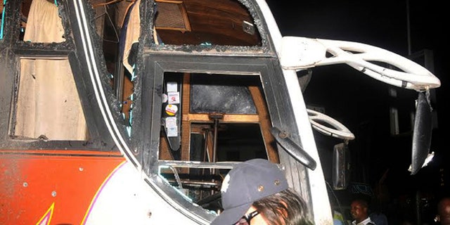 May 3, 2014: People stand near to a bus with windows shattered after an explosion, in Mombasa Kenya