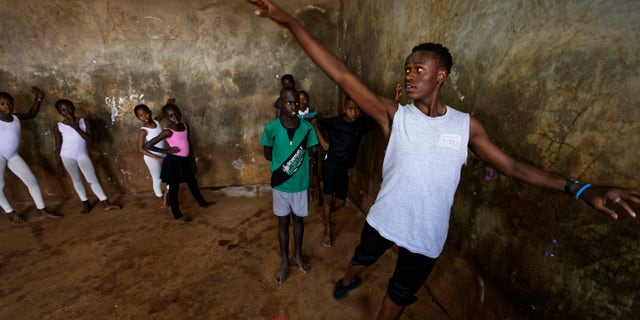 Young ballerinas receive instruction from Kenyan ballet dancer Joel Kioko, 16, in a room at a school in the Kibera slum of Nairobi, Kenya.