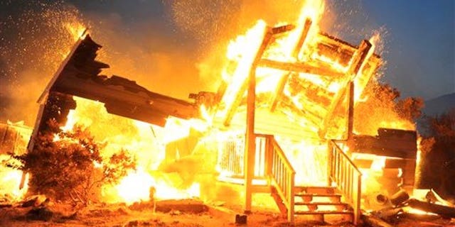 July 27: Two wildfires that erupted and spread quickly in Southern California have destroyed dozens of homes including this house about five miles above Highline Road in Tehachapi and forced evacuations in remote areas of the state's Kern County. More than 30 homes were lost in the small hill community of Old West Ranch and another 150 structures were threatened, firefighters said Tuesday. (AP)