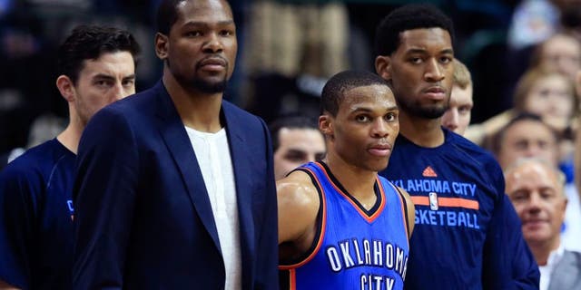 Mar 16, 2015; Dallas, TX, USA; Oklahoma City Thunder forward Kevin Durant (left) and guard Russell Westbrook (0) and forward Perry Jones (right) react on the bench during the second half against the Dallas Mavericks at American Airlines Center. Mandatory Credit: Kevin Jairaj-USA TODAY Sports