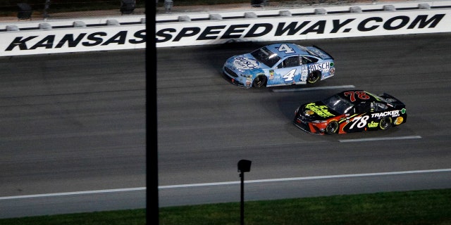 Kevin Harvick (4) passes Martin Truex Jr. (78) with a lap to go to win the NASCAR Cup Series auto race at Kansas Speedway on Saturday, May 12, 2018, in Kansas City, Kan.