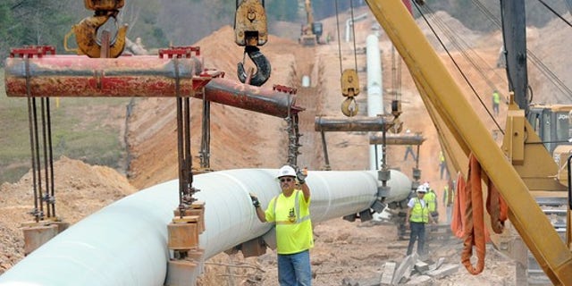 Workers laying parts of the Keystone XL pipeline.